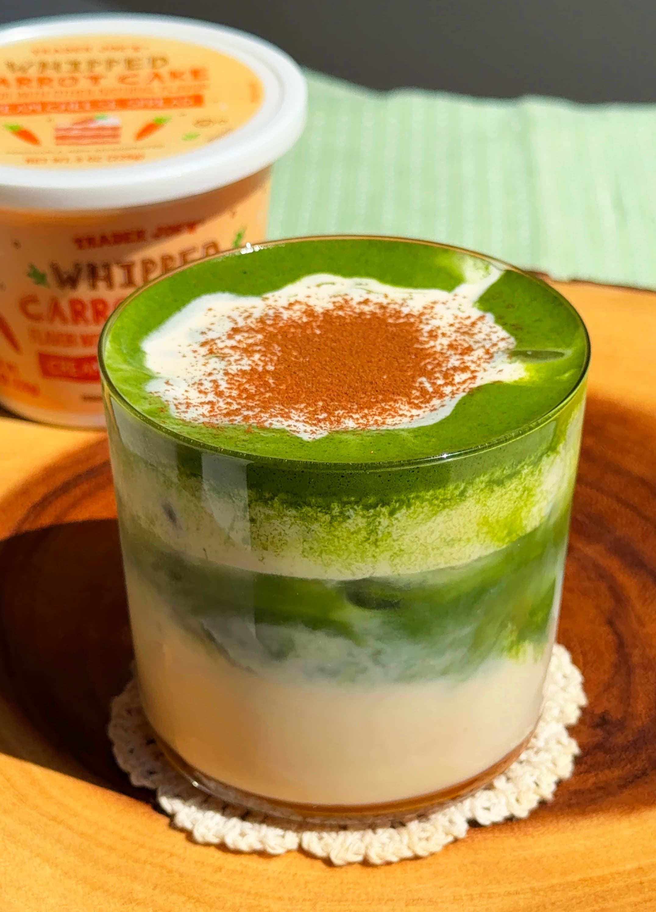 Carrot cake matcha latte with a sprinkle of cinnamon and whipped cream cheese foam