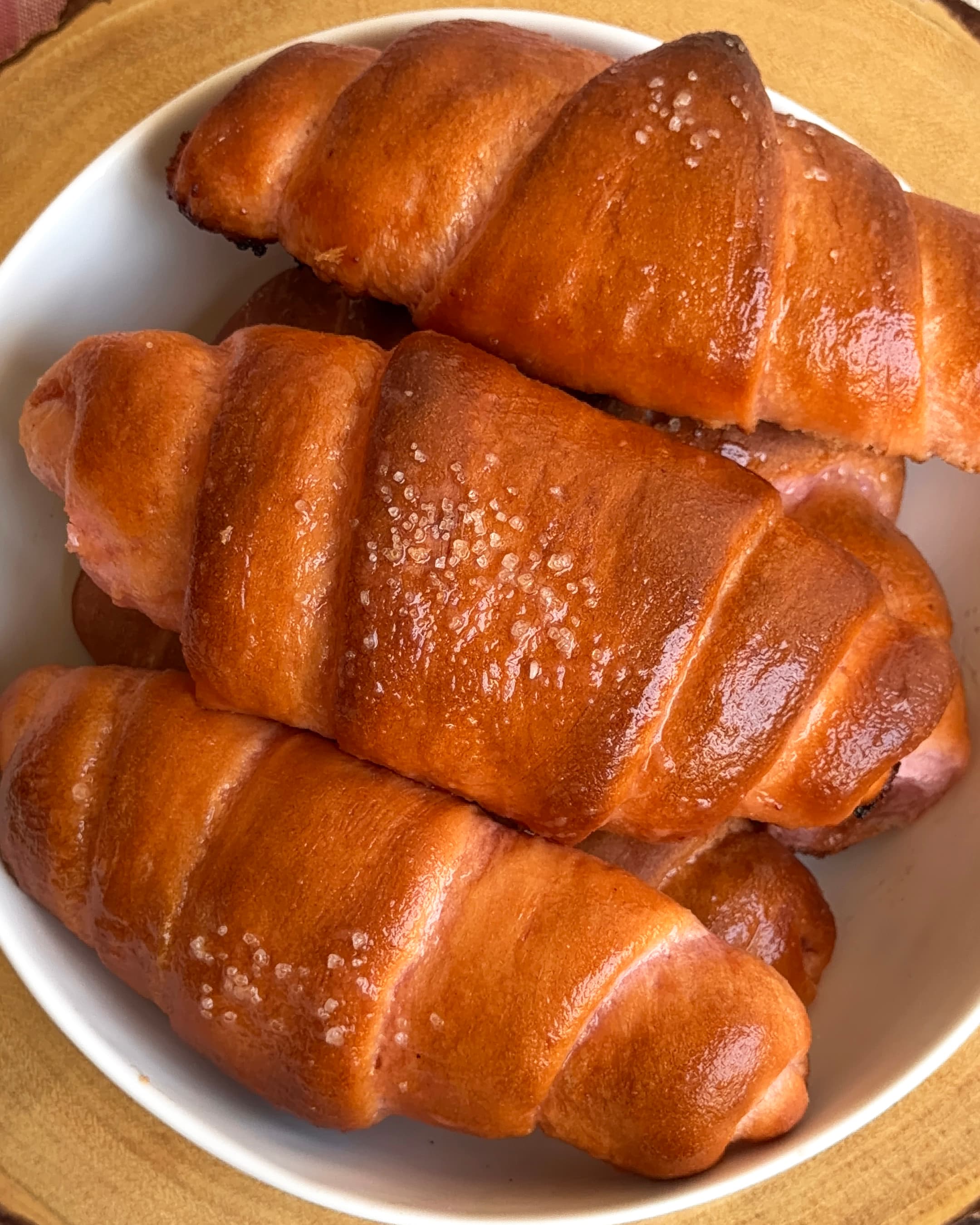 Freshly baked pink guava salt bread rolls topped with pretzel salt