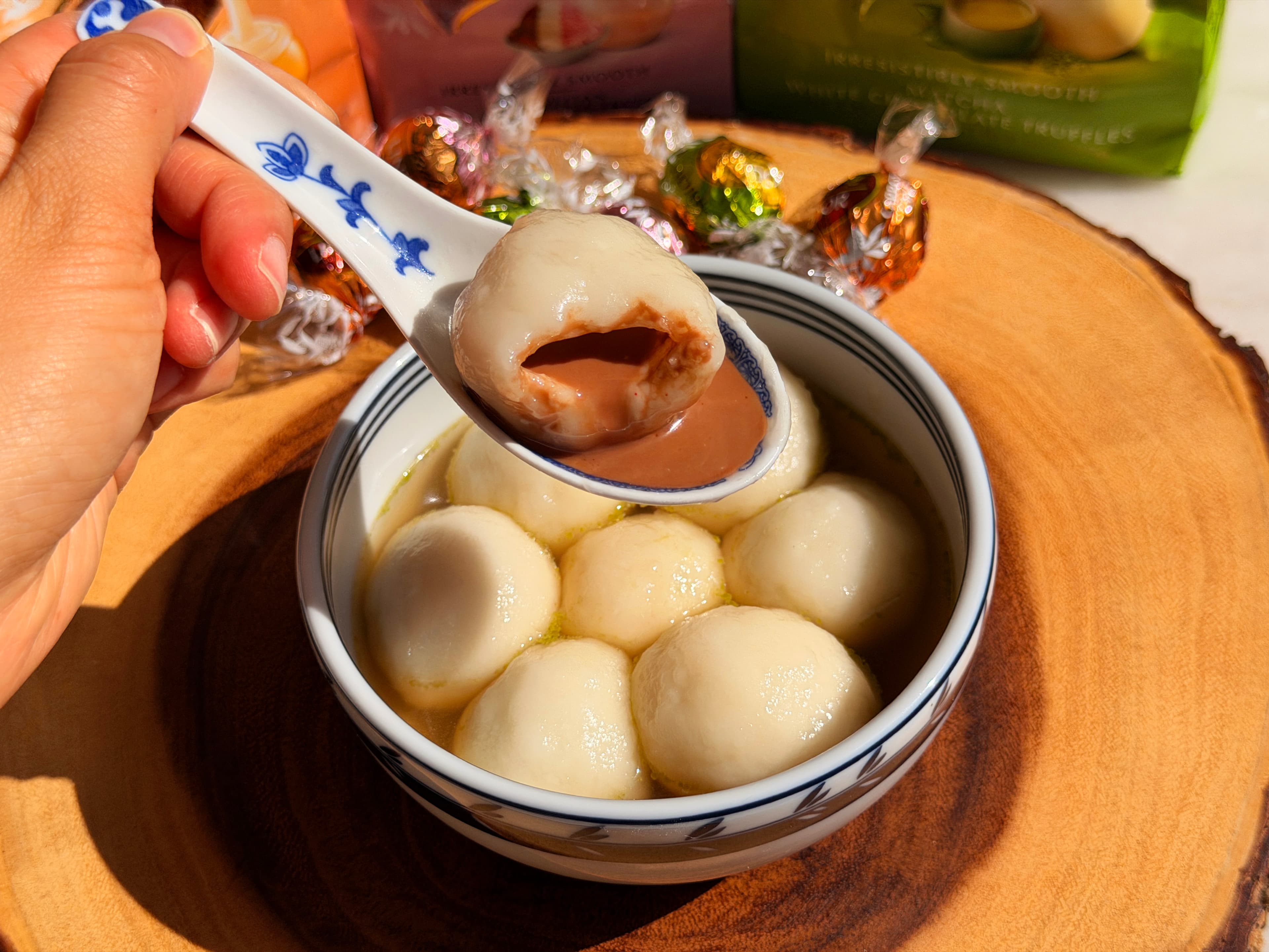 A bite of chocolate-filled tang yuan showing the molten molten lava chocolate center